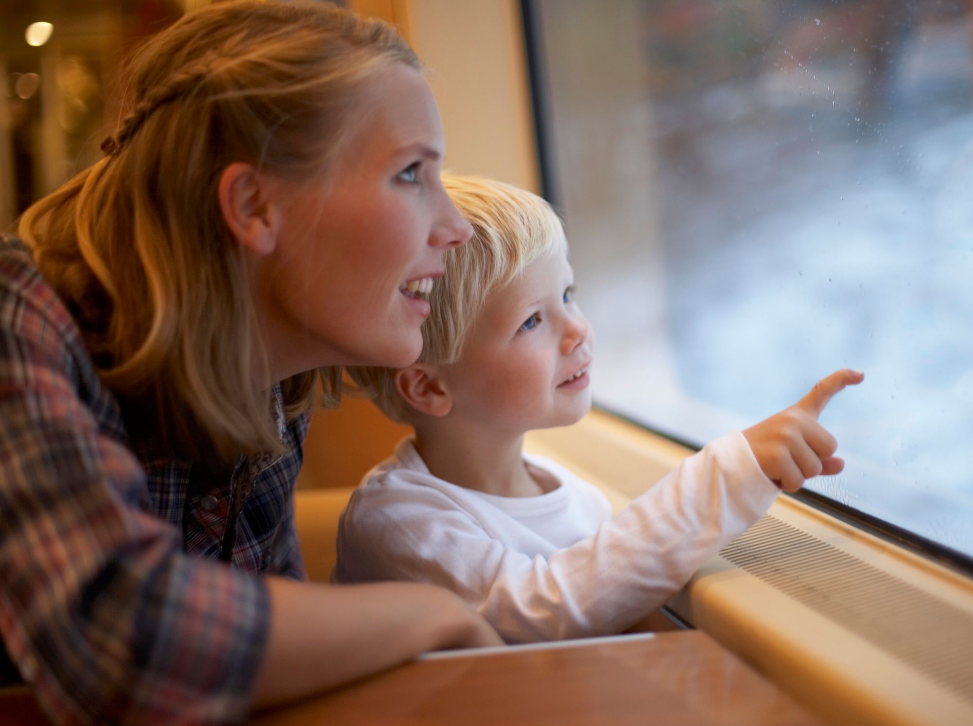 Ung mor med liten gutt ser ut av togvinduet