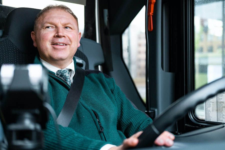 Bilde av Vidar som sitter i bussen med hendene på rattet.