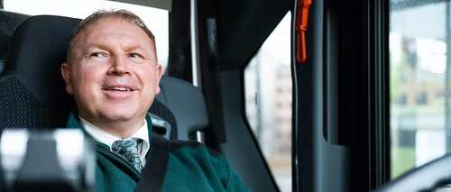 Bilde av Vidar som sitter i bussen med hendene på rattet.