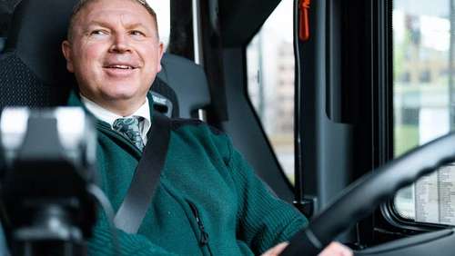 Bilde av Vidar som sitter i bussen med hendene på rattet.