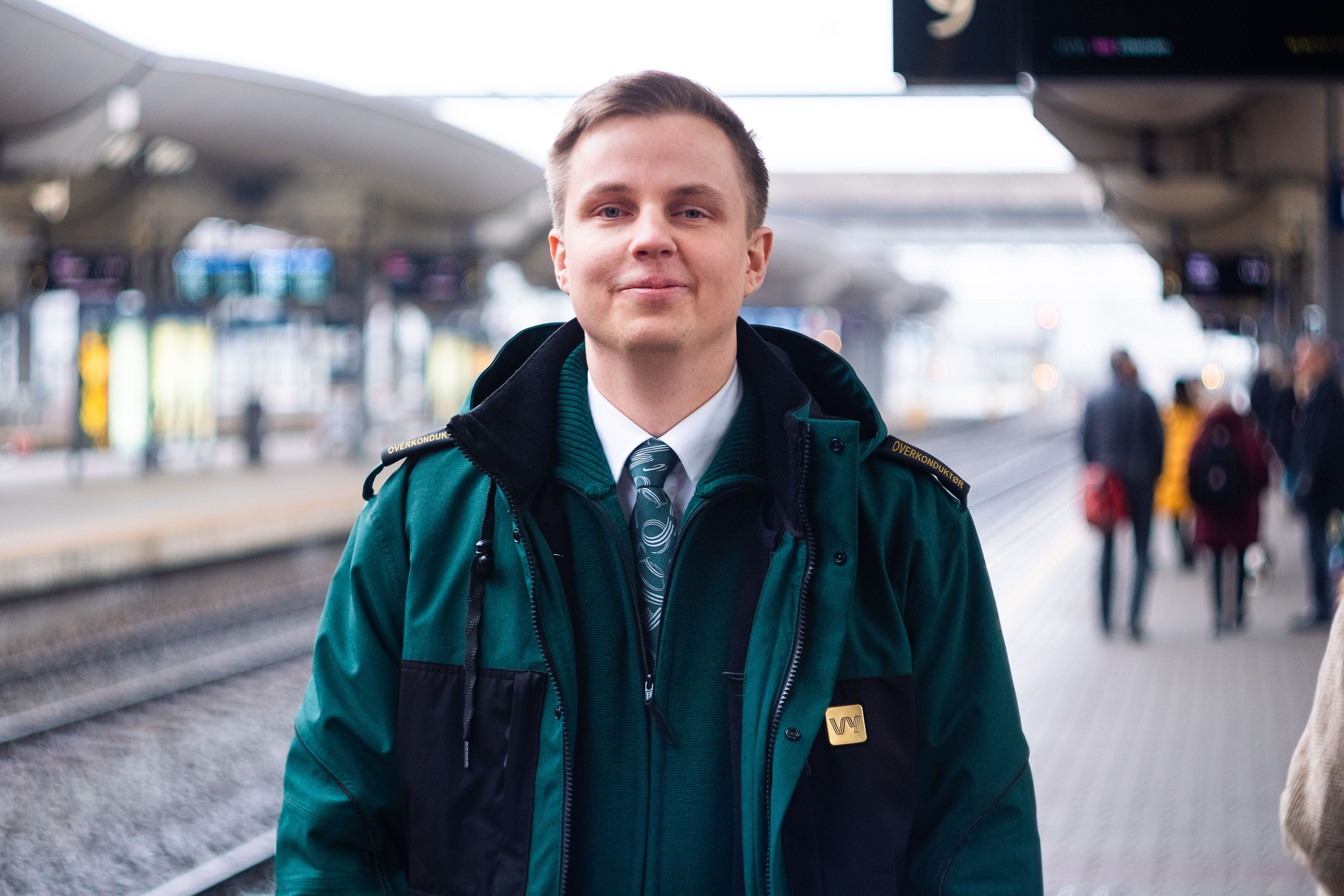 En mann i grønn Vy-jakke