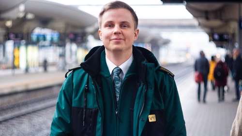 En mann i grønn Vy-jakke