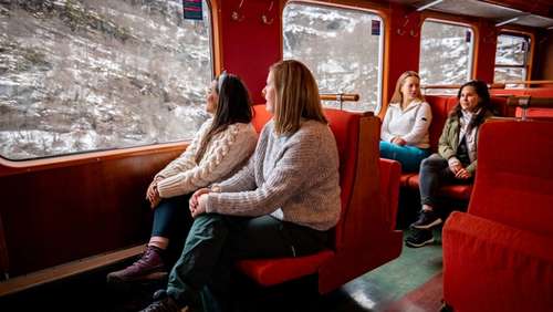 Innsiden av tog med rødt interiør